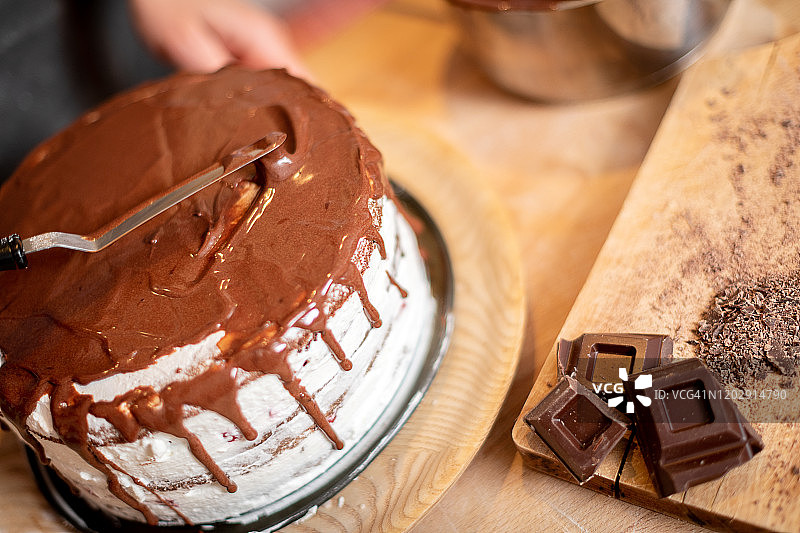 女人在家烘焙:装饰巧克力海绵蛋糕图片素材