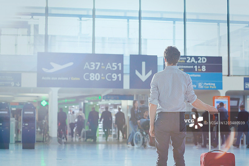 商务旅行，男乘客在机场等待航班图片素材