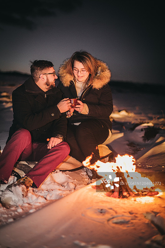 年轻夫妇在享受雪和火图片素材