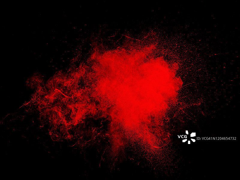 由一团红色粉末颗粒在黑色背景上的冲击而产生的爆炸。图片素材