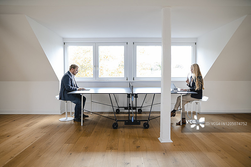 商人和女商人在办公室的乒乓球桌上工作图片素材