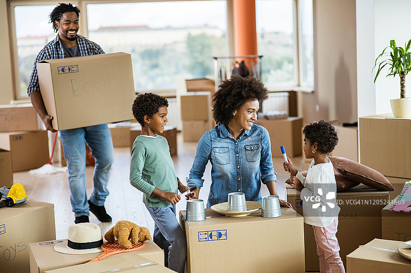 快乐的非裔美国家庭在搬进新家的时候玩得很开心。图片素材
