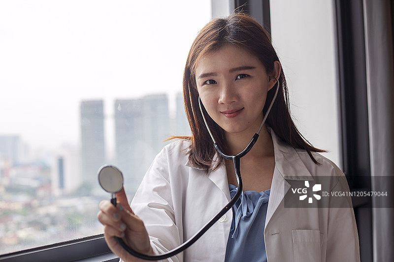 亚洲女医生拿着医疗听诊器在医院治疗病人图片素材