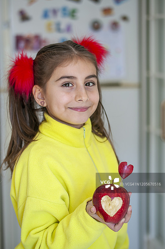女孩手里拿着红色的心形苹果图片素材
