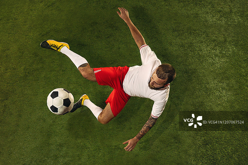 俯视白人足球或足球运动员在绿色草地的背景图片素材