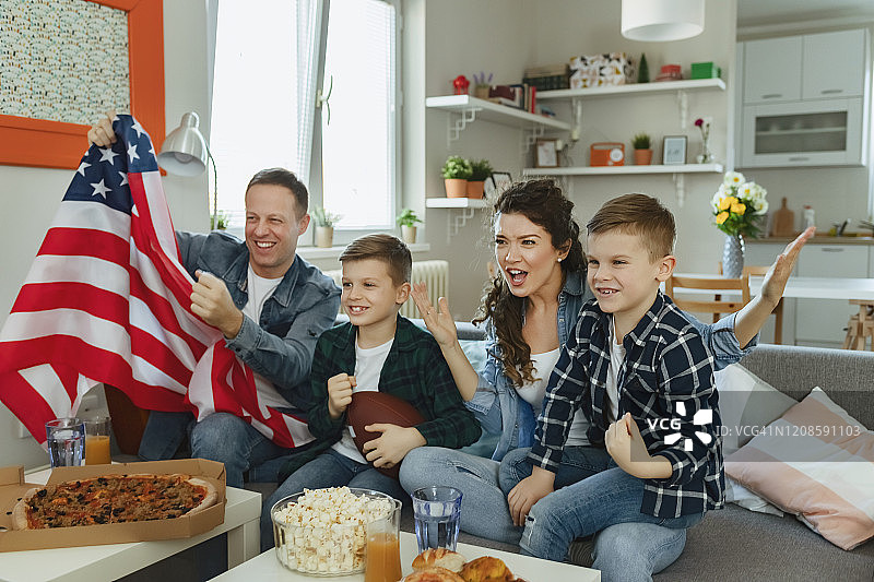 一家人和孩子在电视上看美式足球比赛图片素材