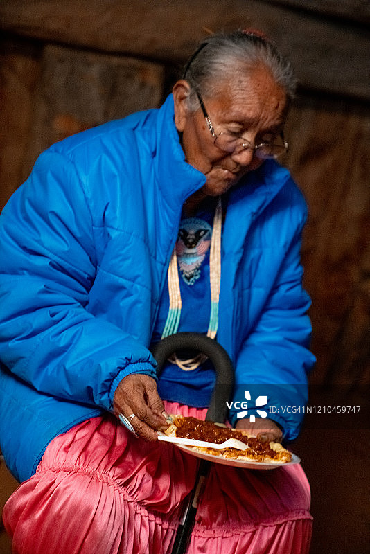 亚利桑那州纪念碑谷，传统的纳瓦霍老妇人正在吃纳瓦霍墨西哥卷图片素材