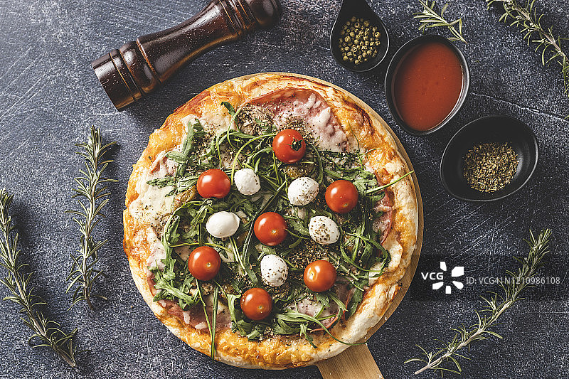 美味的披萨配上马苏里拉奶酪、樱桃番茄和芝麻菜图片素材