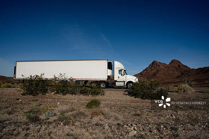 沙漠公路上运送货物的长途半挂车图片素材