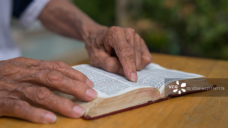 老人坐在外面读她的圣经图片素材