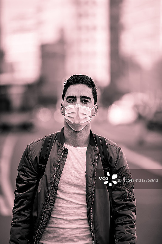 为预防冠状病毒和防雾霾，街头年轻男子戴口罩的肖像图片素材