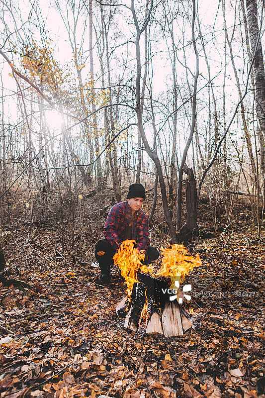 一个人坐在篝火旁，享受着气氛。图片素材