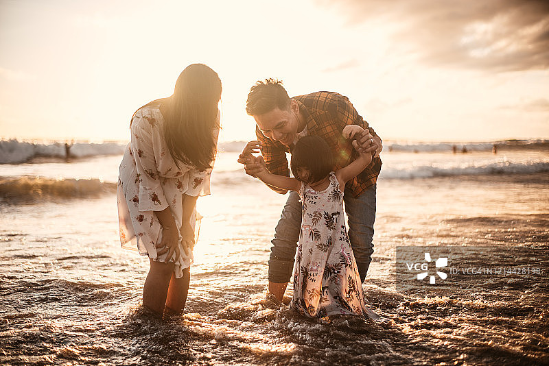 日落时分，印尼家庭在海滩上玩耍图片素材