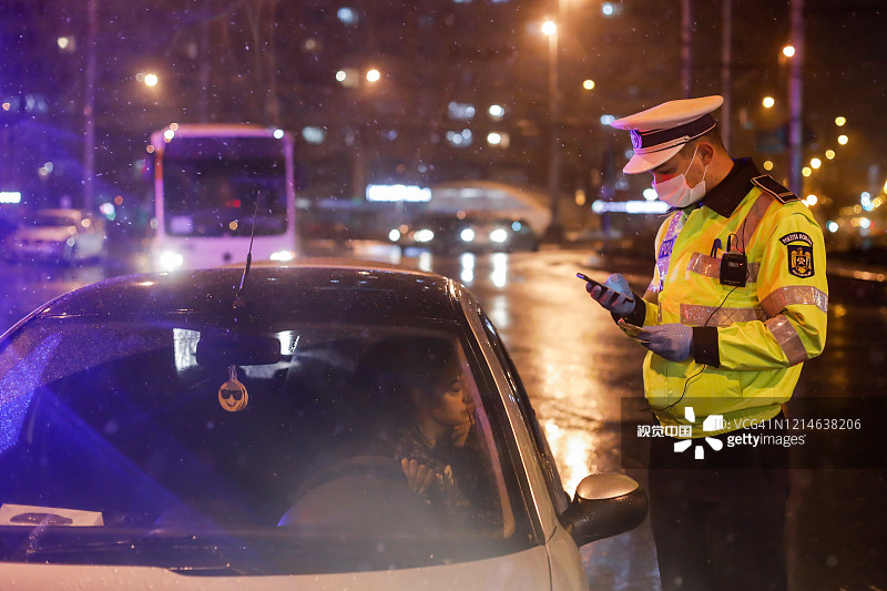 在新冠肺炎疫情蔓延的情况下，警察在布加勒斯特实行宵禁，检查司机及其证件。图片素材