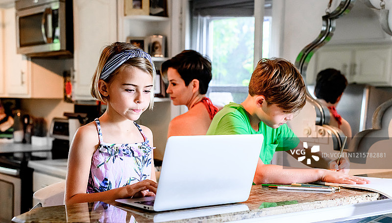 小学年龄的孩子在家里用电脑做作业图片素材