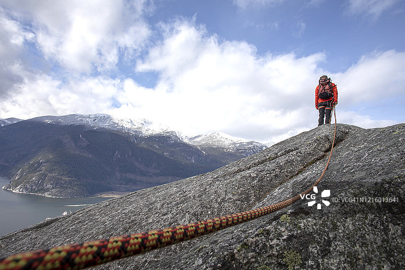 登山者拿着登山绳沿着山脊行走图片素材