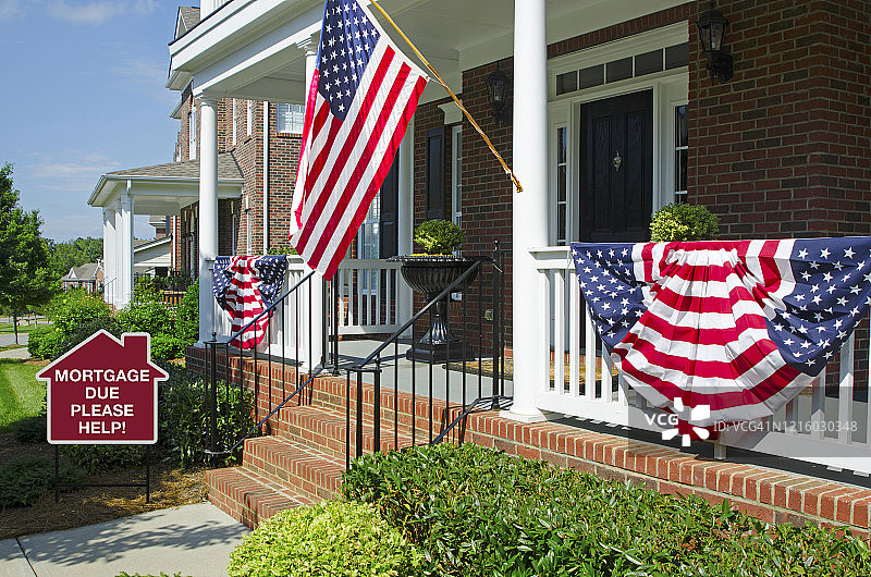 在家门口悬挂着美国国旗和警告金融危机的彩旗图片素材