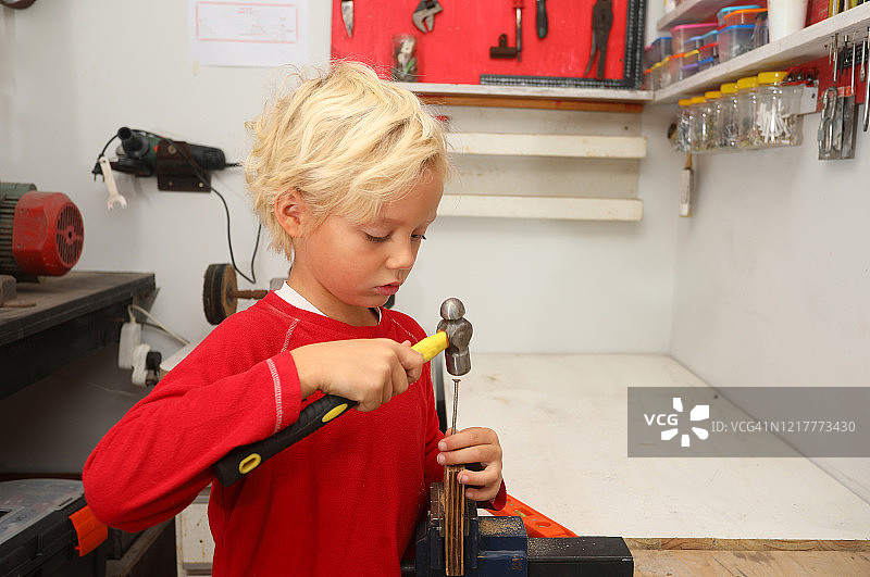 一个和木工工具一起工作的小男孩图片素材
