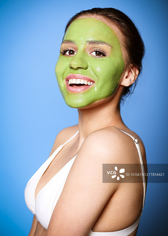 戴着绿色面具的快乐女人图片素材