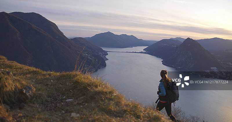 女性徒步旅行者在湖泊和欧洲阿尔卑斯山上行走图片素材