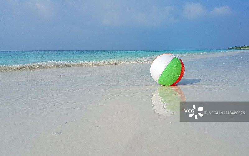 在一个炎热的夏天，在库克群岛被海浪冲刷的白色沙滩上的沙滩球，复制空间图片素材