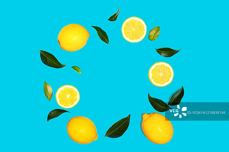 创意的布局，飞行黄色柠檬与树叶在绿色薄荷色的背景。图片素材