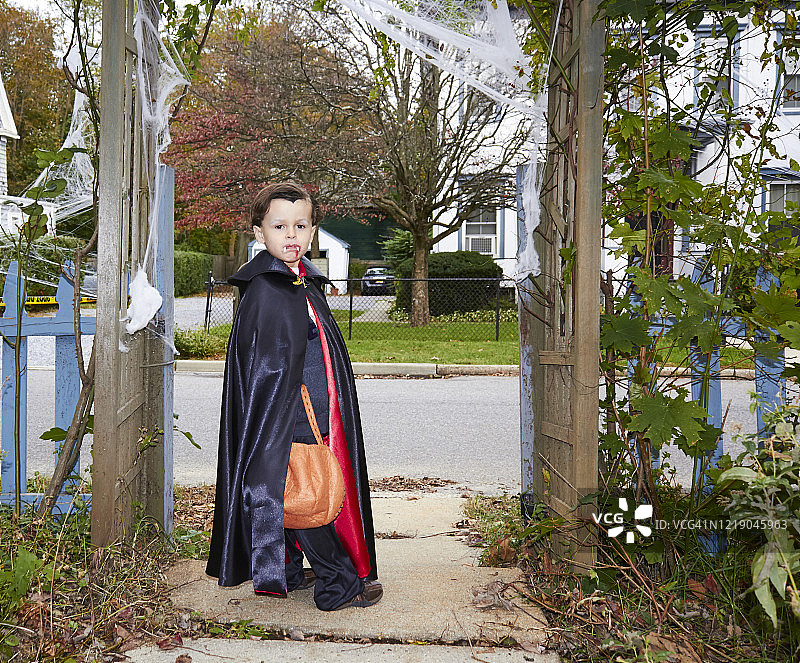 万圣节那天，小男孩穿着德古拉的万圣节服装在外面。图片素材