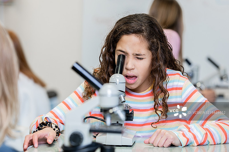 女学生使用显微镜观察显微镜图像图片素材