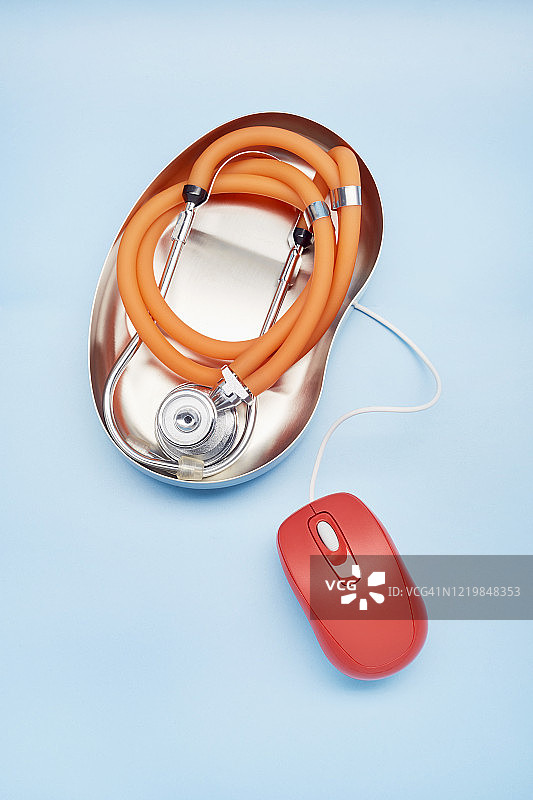 高视角听诊器和红色电脑鼠标在蓝色背景图片素材
