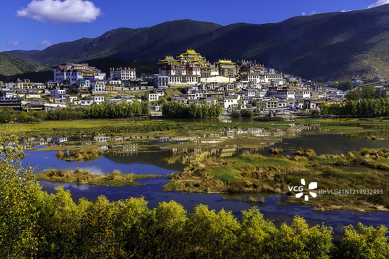 远处的松赞林寺与它的反射在香格里拉，云南，中国。图片素材