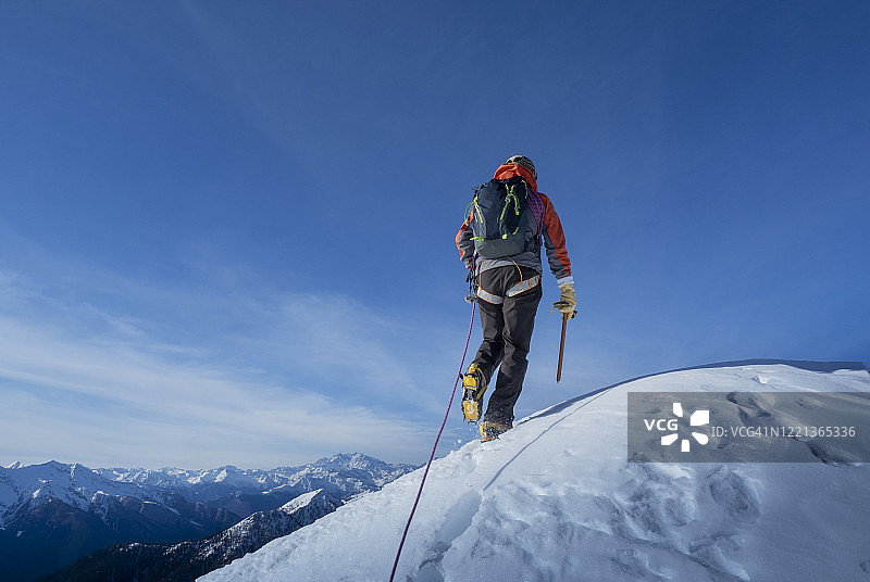 攀登者到达白雪皑皑的山顶图片素材