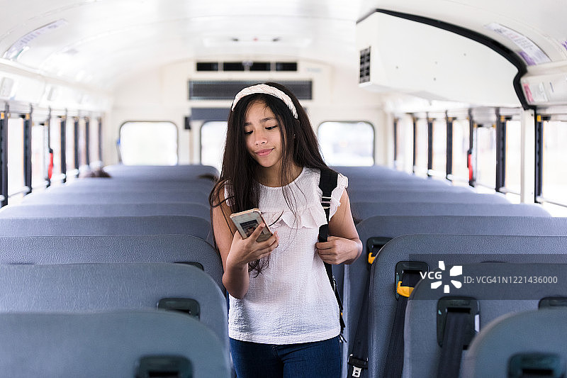 年轻女孩走在公交通道上，却被智能手机分心了图片素材