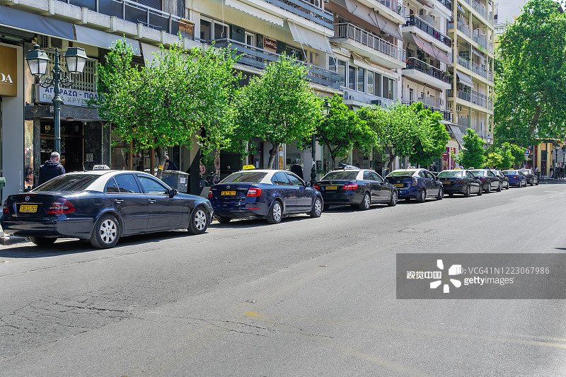 蓝色和白色的出租车和司机，停在的士站，在Mitropoleos街。图片素材