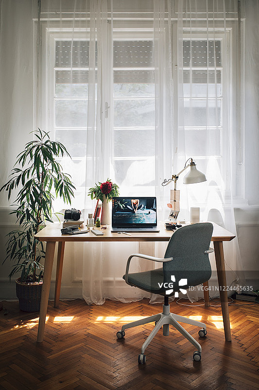 在家工作:一个女商人的临时家庭办公室，桌上的笔记本电脑图片素材