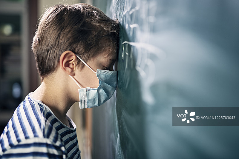 2019冠状病毒病大流行期间，小男孩因上学而抑郁。图片素材