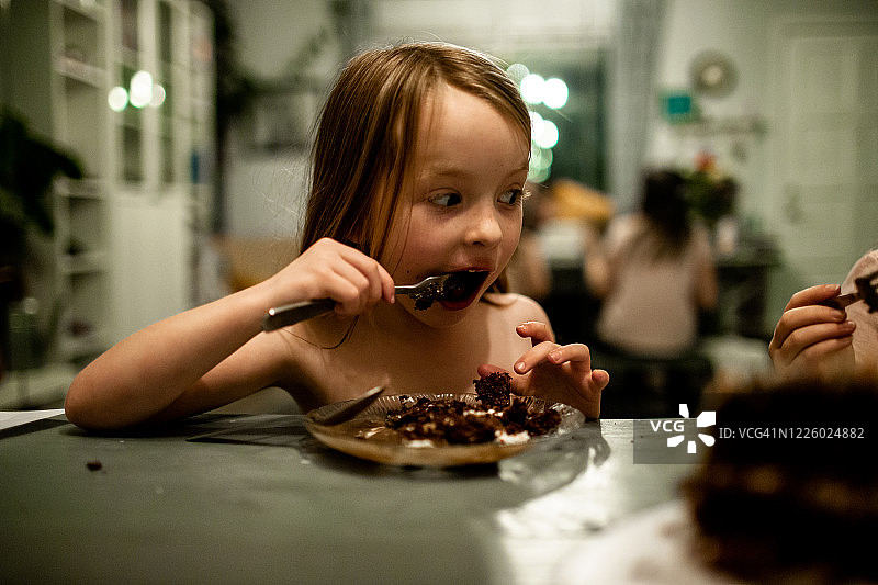 年轻女孩吃蛋糕时脸上带着惊讶图片素材