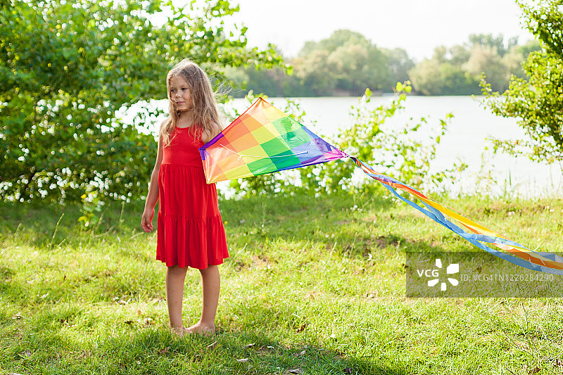 孩子在户外玩风筝，日落，在夏天的一天。和家人在一起的快乐时光。快乐的小女孩放风筝图片素材