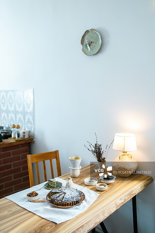 漂亮风格的木制餐桌为早餐设置。天然有机早餐，新鲜烘焙的蛋糕，干果，果酱，咖啡，牛奶壶，亚麻桌布和陶瓷餐具。副本的空间。图片素材