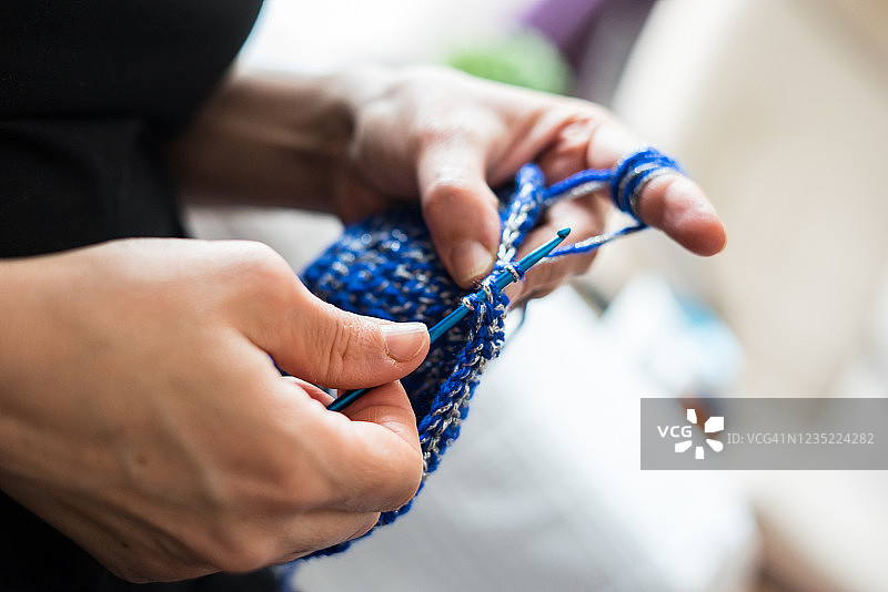 一个女人编织蓝色的包手工工艺品图片素材