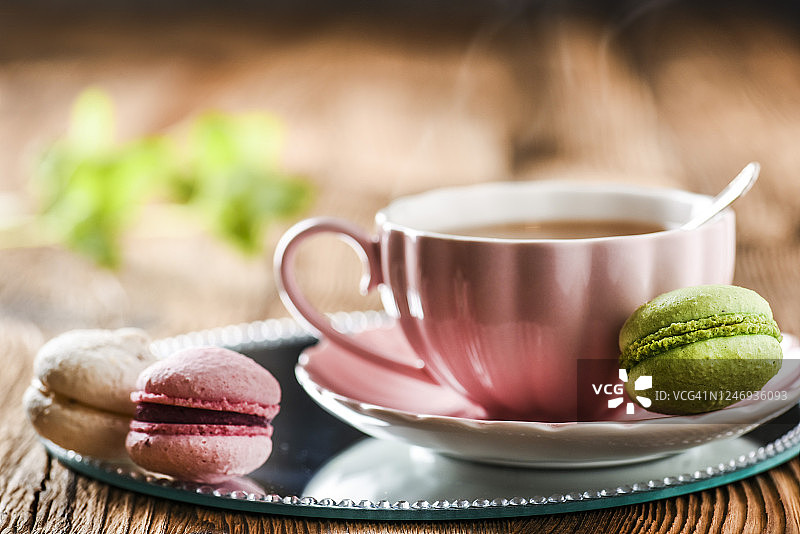 甜蛋糕马卡龙和绿茶。五颜六色的马卡龙配茶图片素材