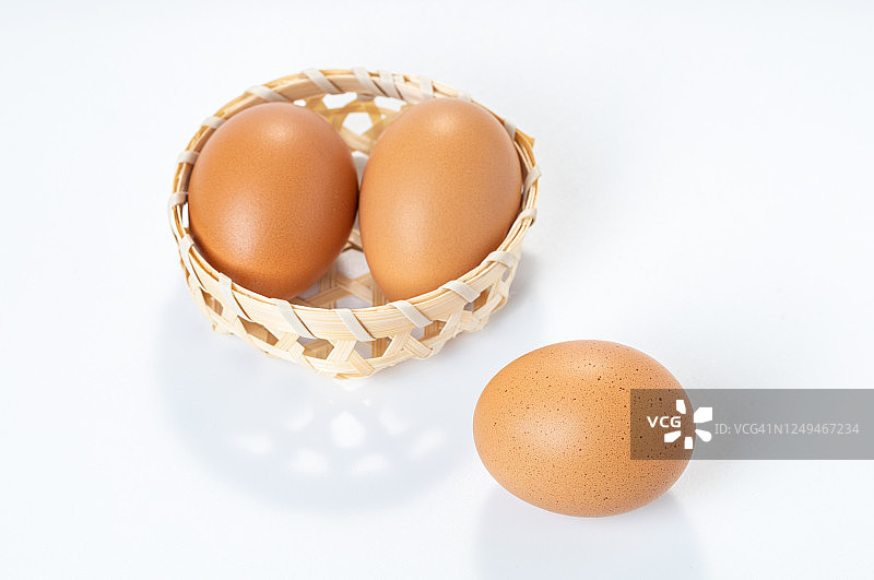 白色背景下的篮子里的鸡蛋图片素材