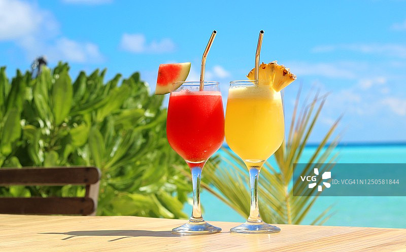 新鲜的热带饮料菠萝和西瓜汁在玻璃上美丽的海洋背景，复制空间图片素材