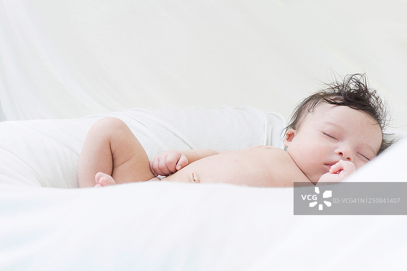 可爱的小婴儿睡在她的婴儿床里图片素材