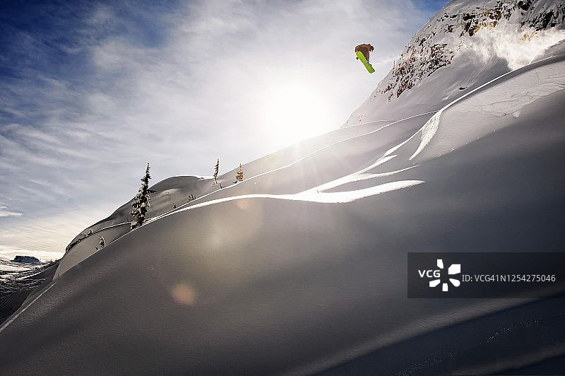 滑雪者在一个深的火药山脊上的跳跃获得空气图片素材