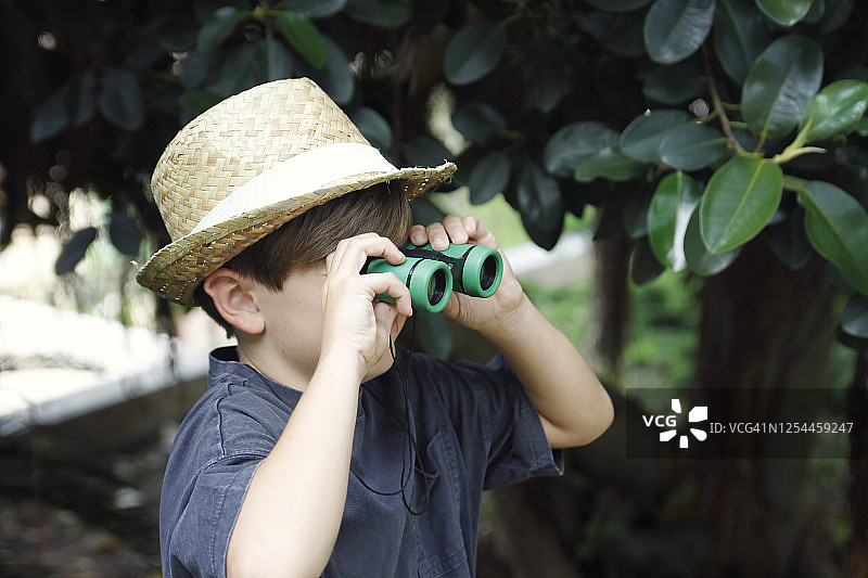 男孩用双筒望远镜探索大自然图片素材
