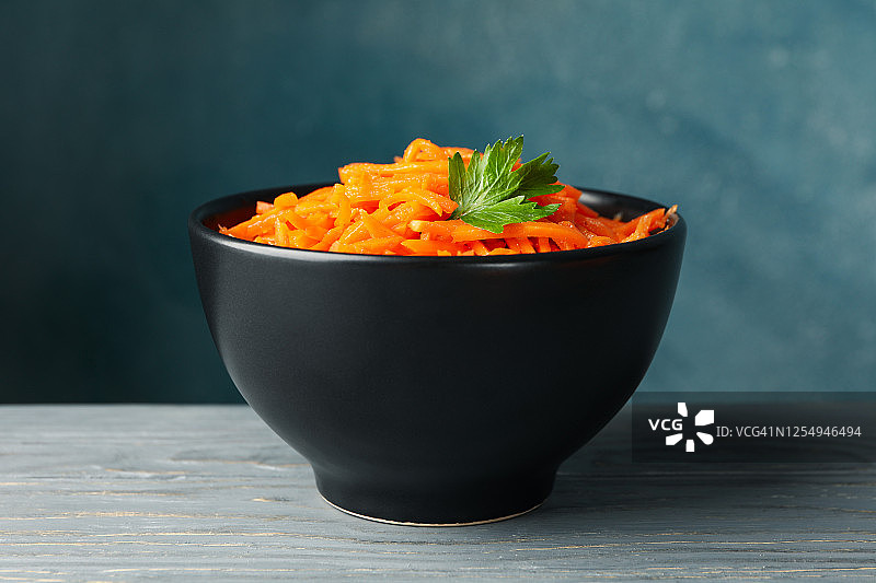 灰色的桌子上有一碗胡萝卜沙拉。韩国食物图片素材