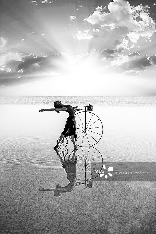 芭蕾舞演员在湖上骑着旧自行车跳舞图片素材
