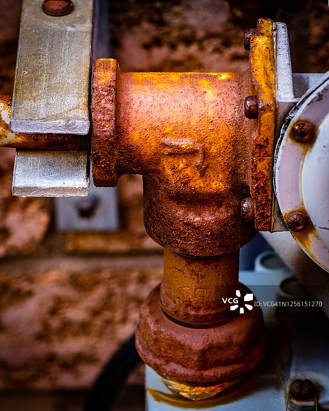 生锈的旧气泵与螺丝和管道。图片素材