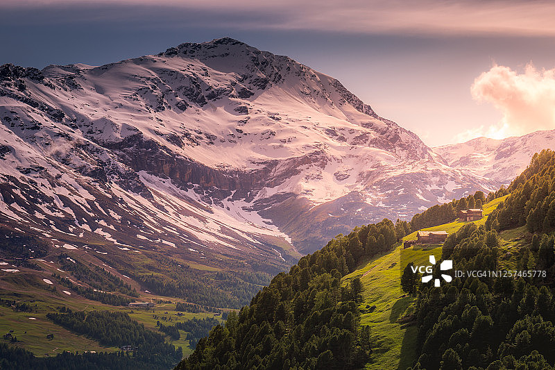 意大利阿尔卑斯山，斯特尔维奥国家公园的白雪皑皑的山上有小屋和谷仓图片素材