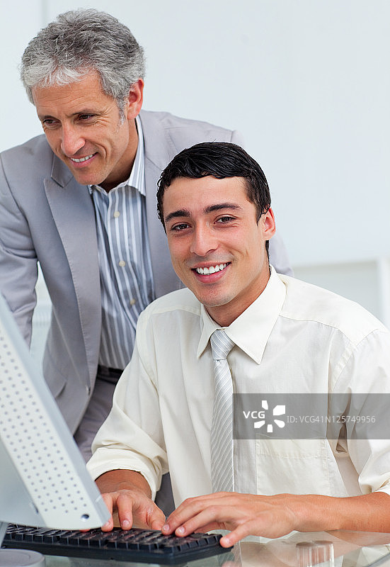 自信的商人在电脑前帮助他的同事图片素材